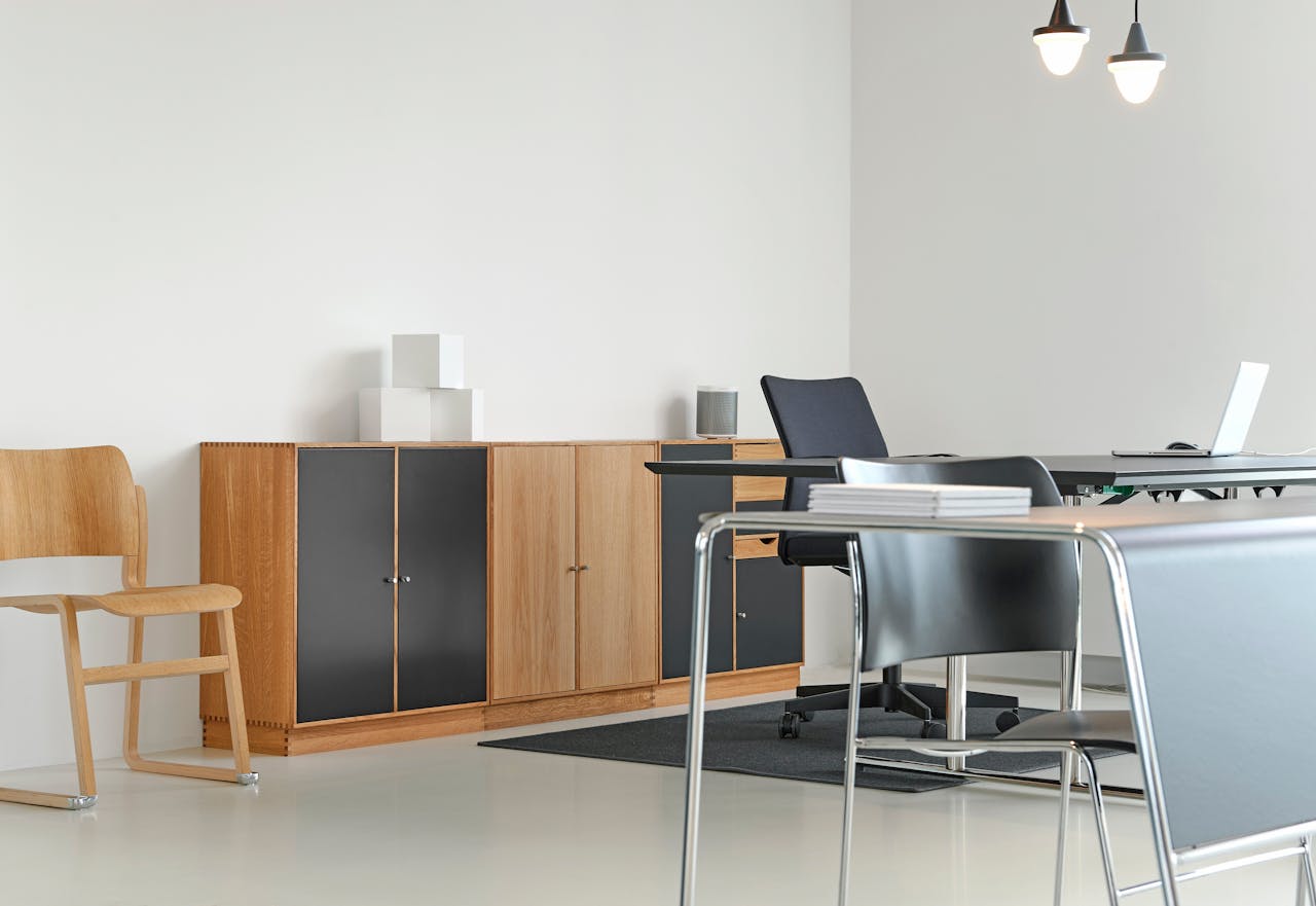 about-01 A clean and organized modern office space with stylish furniture and decor.