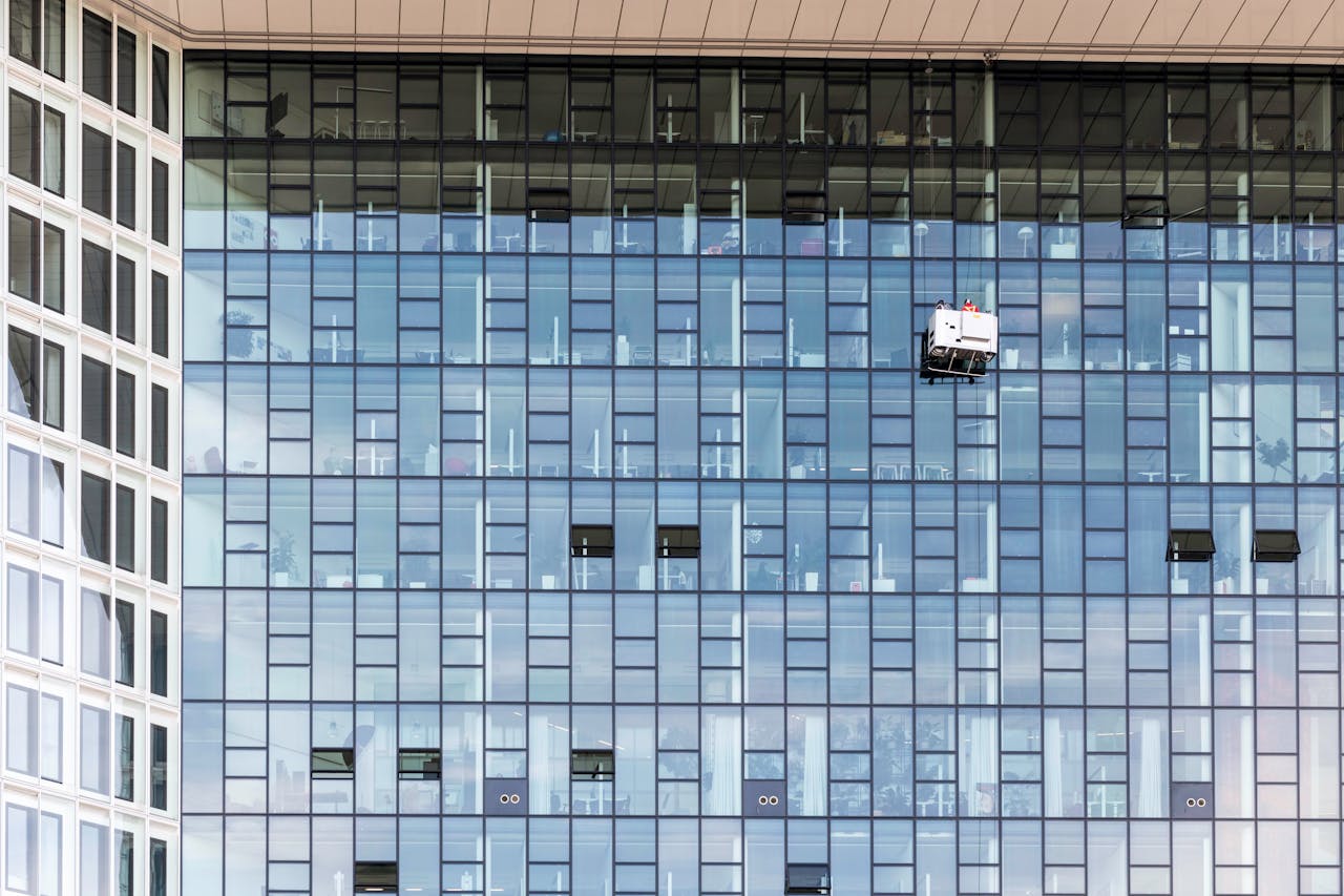 services-03 High-rise glass building exterior with window cleaners in Hamburg, Germany.